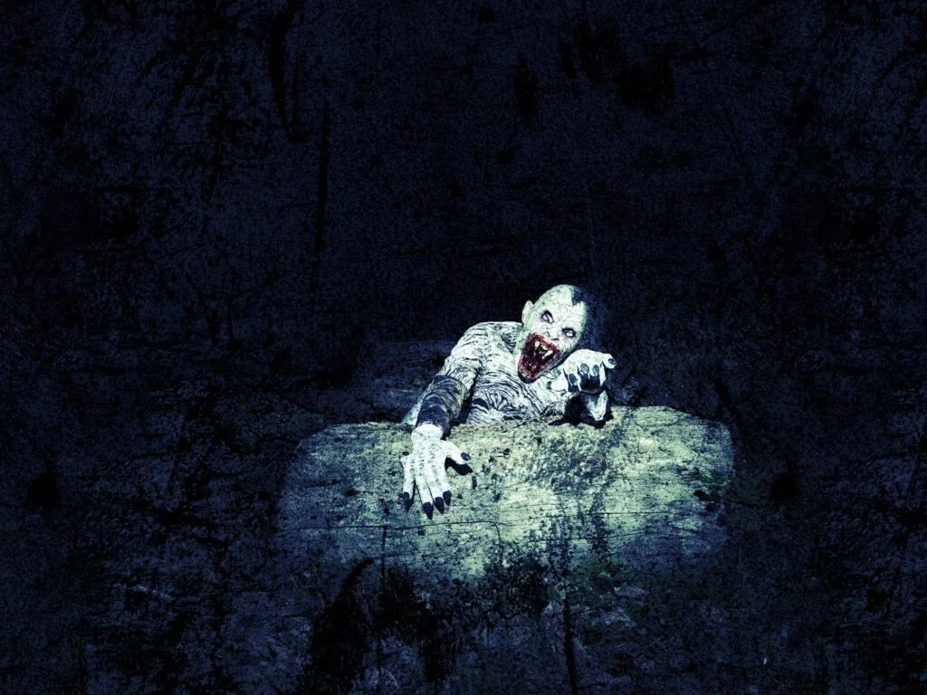 A pale, monstrous figure with long black claws and sharp teeth emerges menacingly from behind a stone slab in a dark, textured setting—the perfect nightmarish centerpiece for any Gothic Multimedia Project. Its wide eyes and open mouth create a terrifying effect.